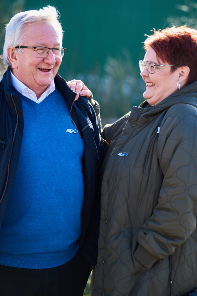 To personer i samtale, den ene med demenssymbolet synligt.