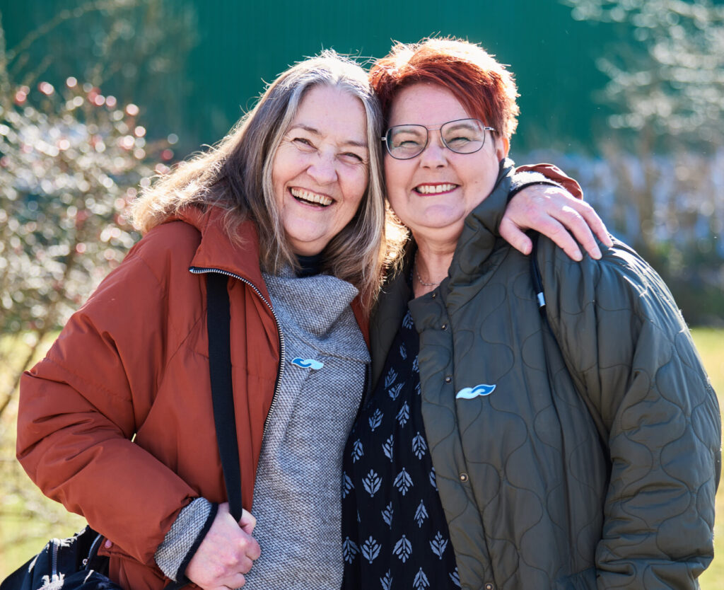 To veninder med demenssymbolet griner sammen