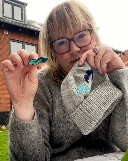 Strikkedesigner, iværksætter, blogger med demenssymbolet