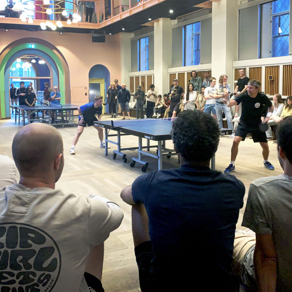 Frivillige hjælper deltagere ved bordtennisbord i Absalon